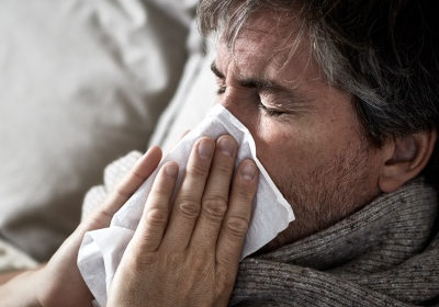 Man blowing nose during illness